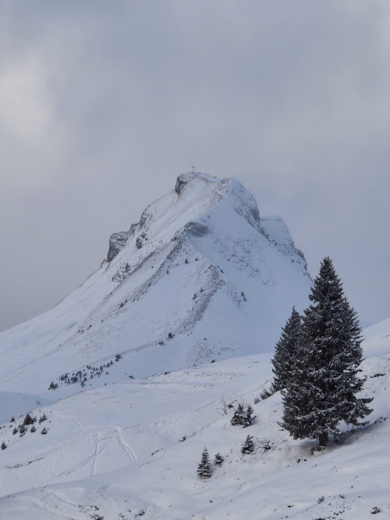 Snow-covered mountain with cross