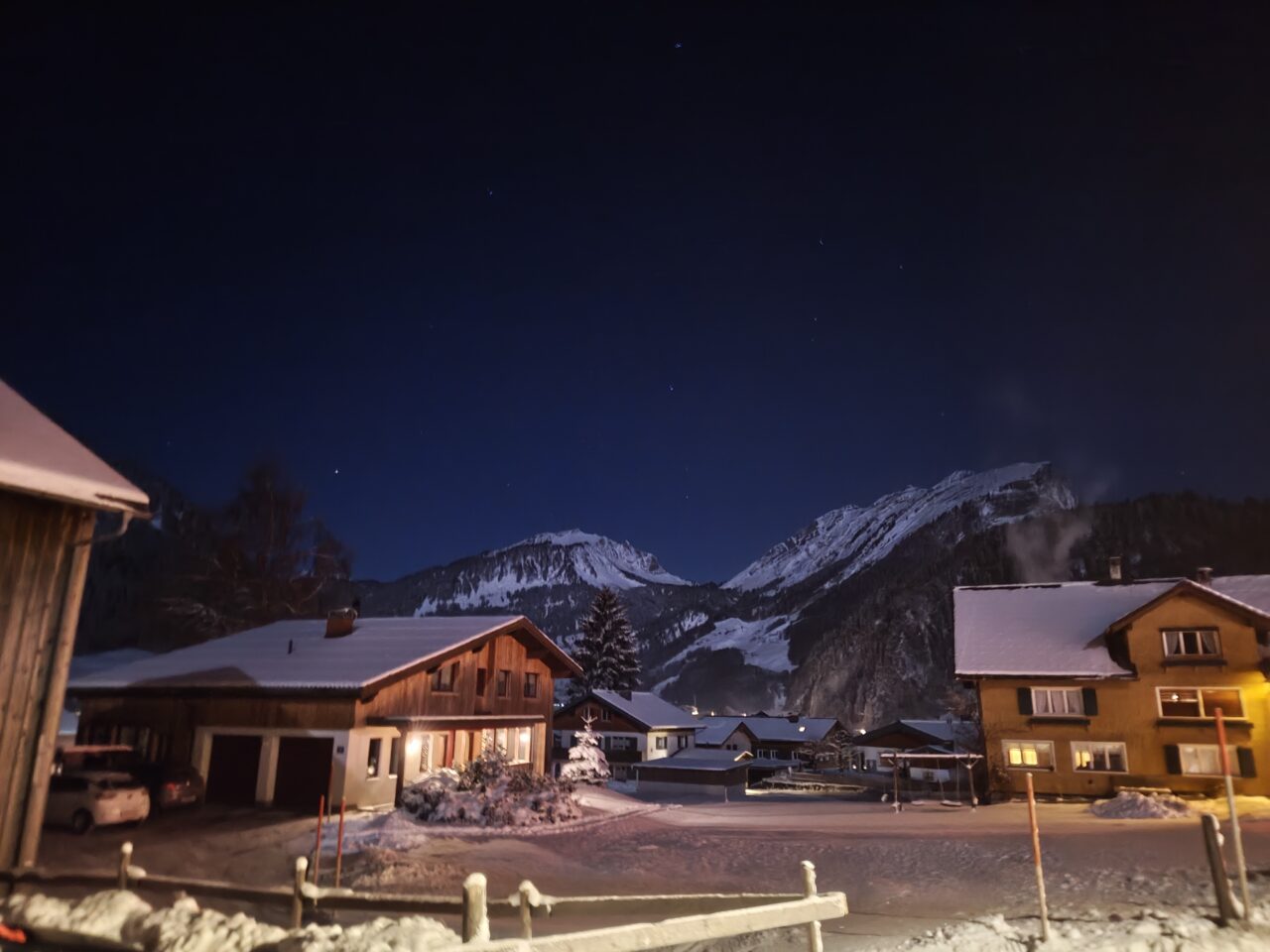 Night view of winter village with mountains and stars